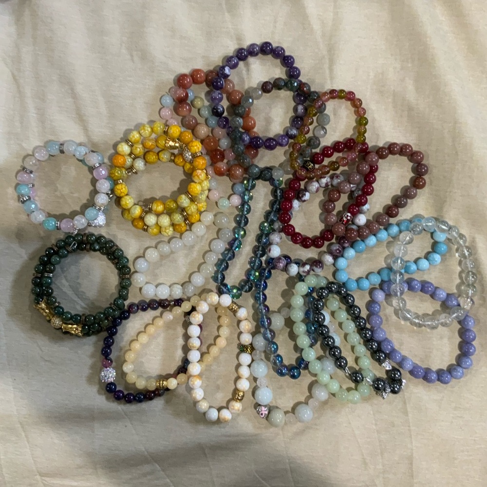 Lot of 23 mixed crystals and natural stone beaded bracelets.